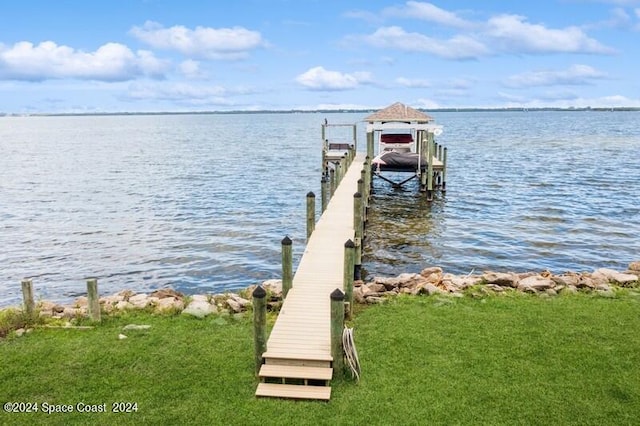 dock area with a water view and a lawn