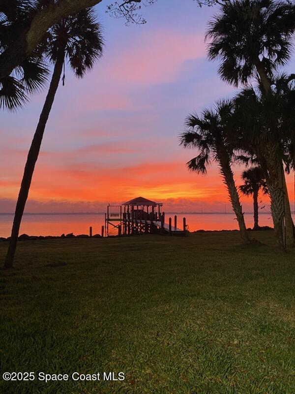 yard at dusk featuring a water view