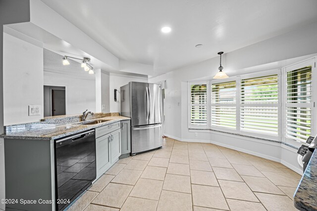 kitchen featuring black dishwasher, rail lighting, light tile patterned floors, and stainless steel fridge