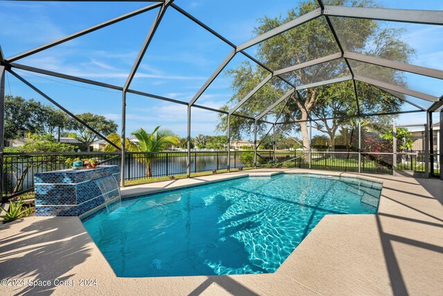 view of pool with a water view, a lanai, pool water feature, and a patio area