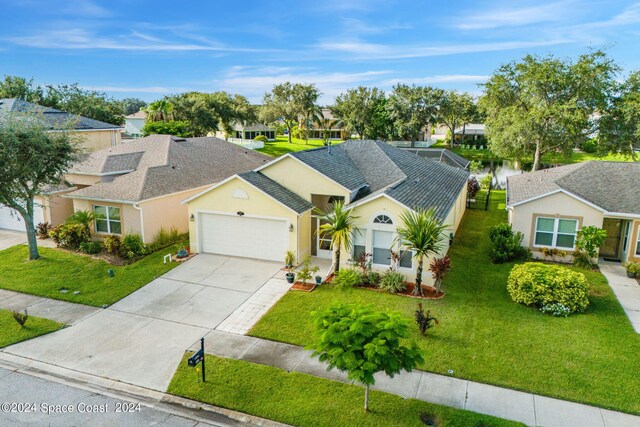 single story home with a water view, a garage, and a front lawn