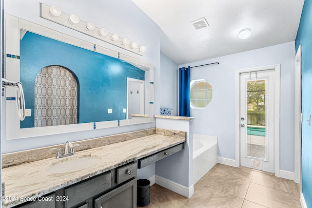 bathroom with vanity, tile patterned flooring, and a bathtub