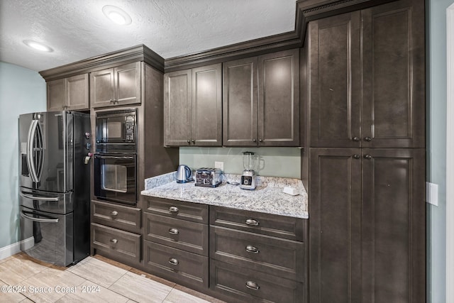 kitchen featuring light tile patterned flooring, black appliances, light stone counters, and dark brown cabinets