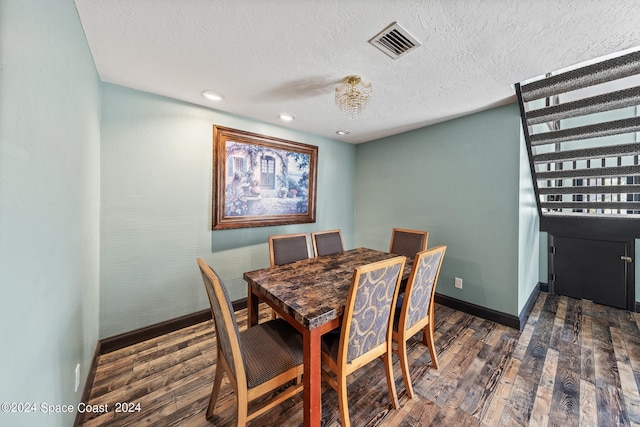 dining space featuring a textured ceiling and dark hardwood / wood-style floors