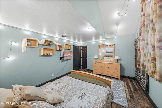 bedroom featuring a textured ceiling and dark hardwood / wood-style floors