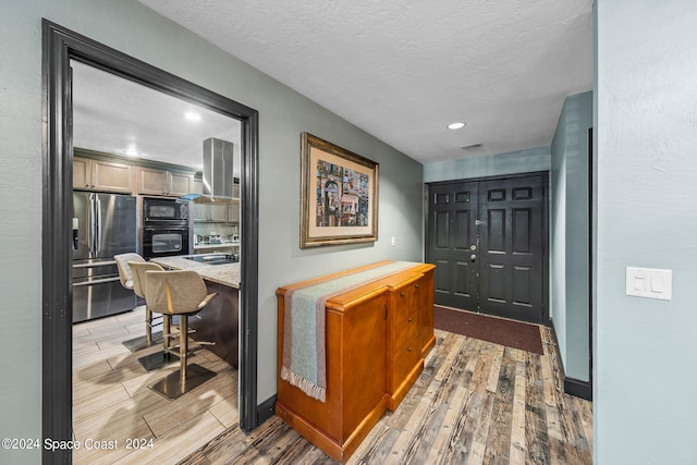 hallway featuring hardwood / wood-style flooring and a textured ceiling