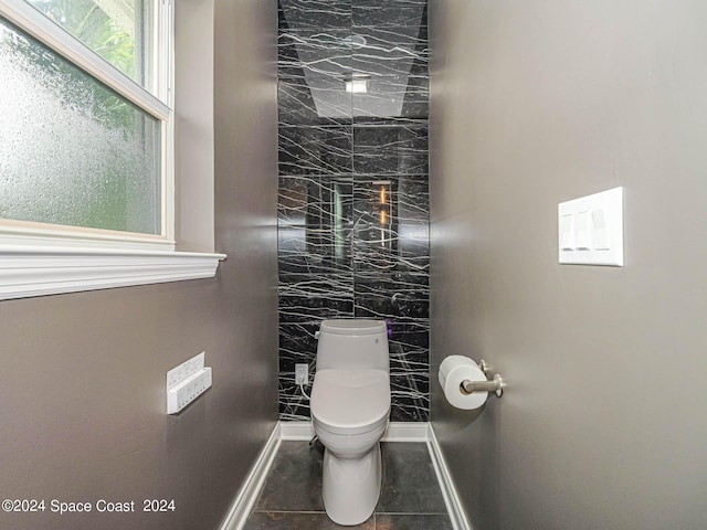 bathroom with walk in shower, tile patterned flooring, and toilet