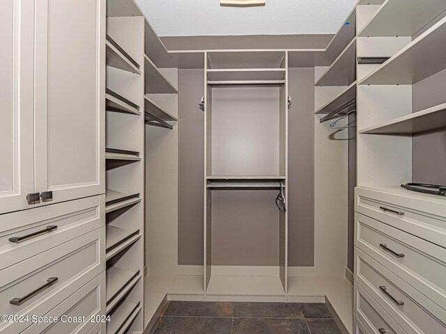 walk in closet featuring dark tile patterned floors