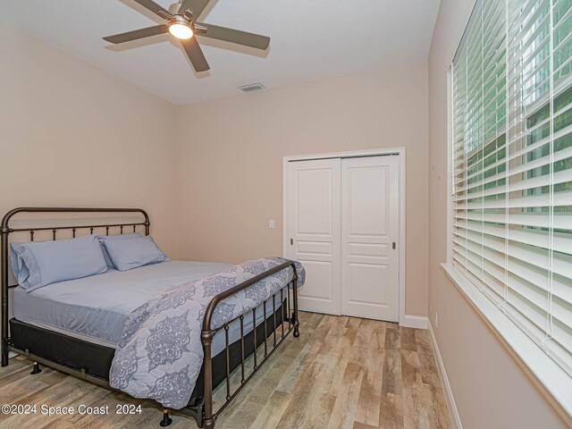 bedroom featuring ceiling fan, light hardwood / wood-style floors, and a closet