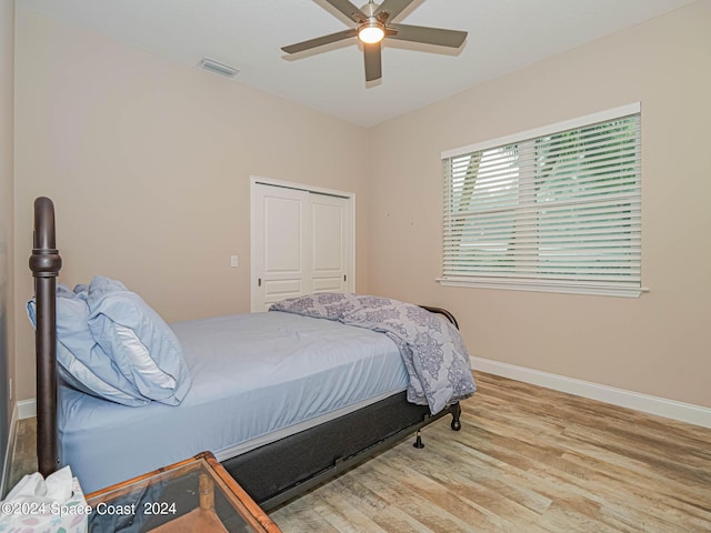 bedroom with light hardwood / wood-style flooring, a closet, and ceiling fan