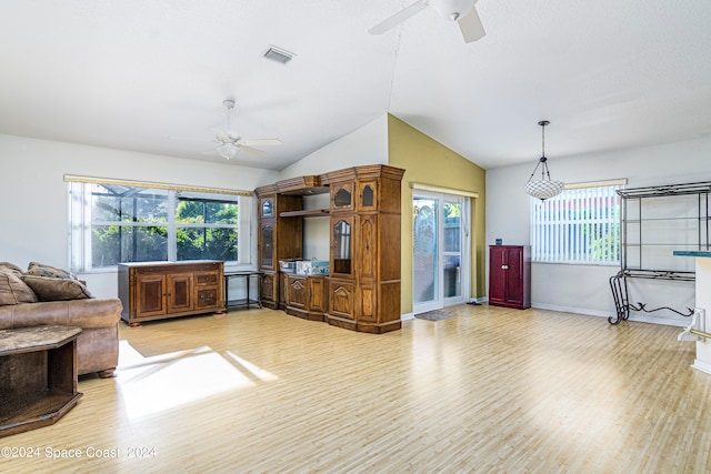 living room featuring light hardwood / wood-style flooring, ceiling fan, and vaulted ceiling