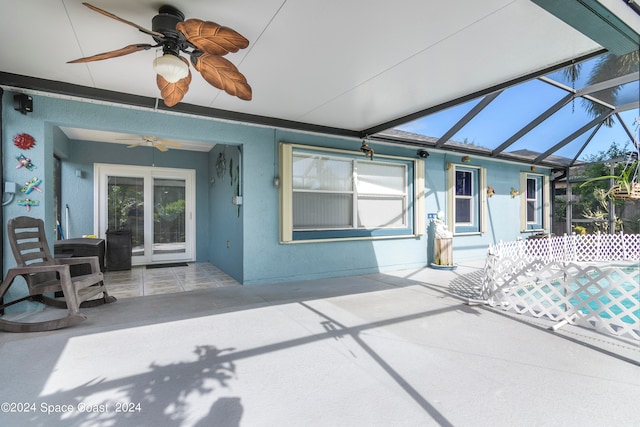 view of patio / terrace with ceiling fan and glass enclosure