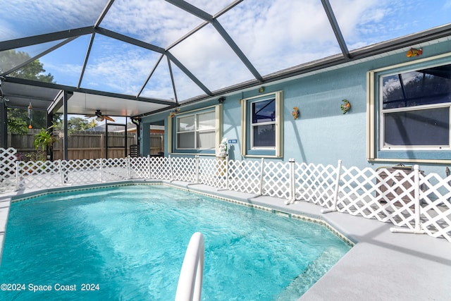 view of pool featuring ceiling fan and a lanai