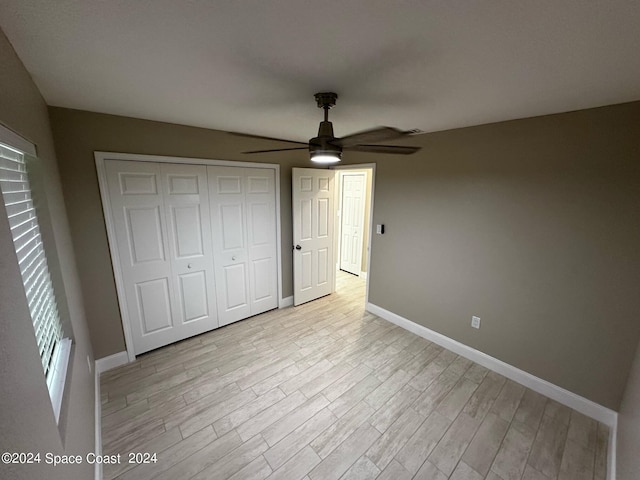 unfurnished bedroom featuring ceiling fan, light wood-type flooring, and a closet