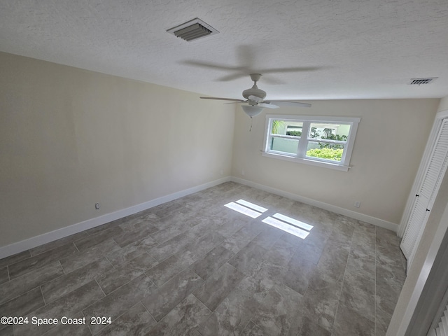 spare room featuring ceiling fan and a textured ceiling