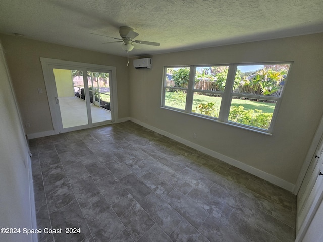 unfurnished room featuring ceiling fan, a textured ceiling, and a wall unit AC