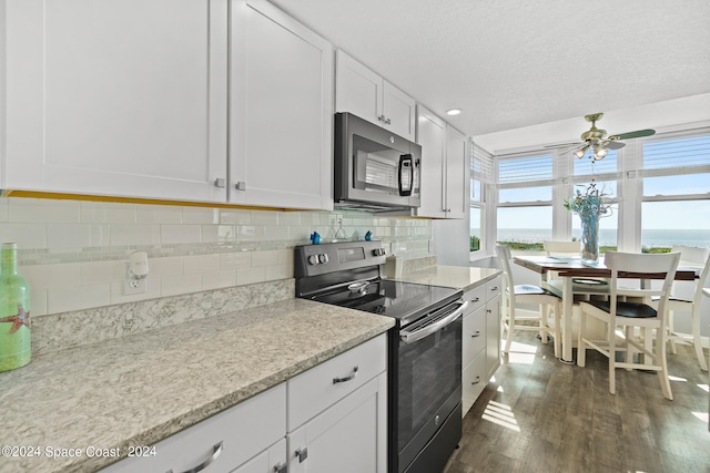 kitchen with ceiling fan, backsplash, dark hardwood / wood-style flooring, white cabinetry, and range with electric stovetop