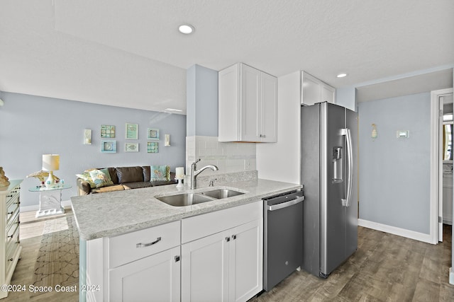 kitchen featuring backsplash, dark hardwood / wood-style flooring, white cabinetry, sink, and stainless steel appliances