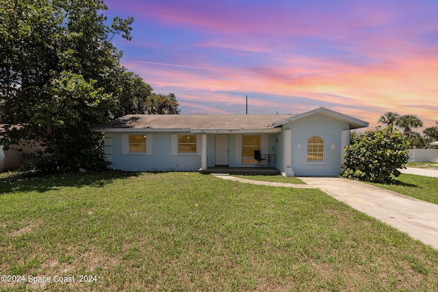 single story home featuring a lawn