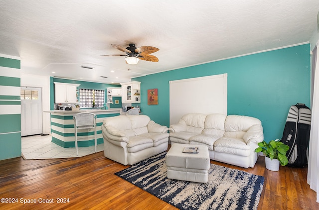 living room featuring ceiling fan, a textured ceiling, and light hardwood / wood-style flooring