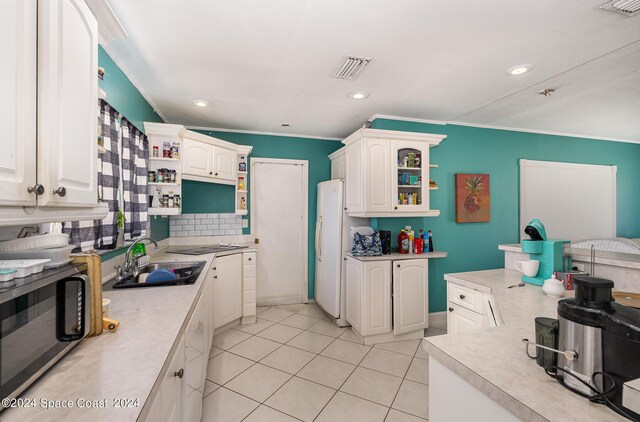 kitchen featuring white cabinetry, backsplash, sink, white refrigerator, and light tile patterned flooring