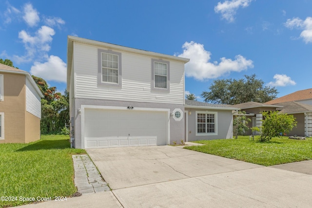 traditional-style house with a front yard, concrete driveway, an attached garage, and stucco siding