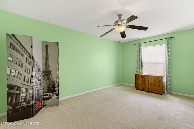 unfurnished room featuring ceiling fan and carpet