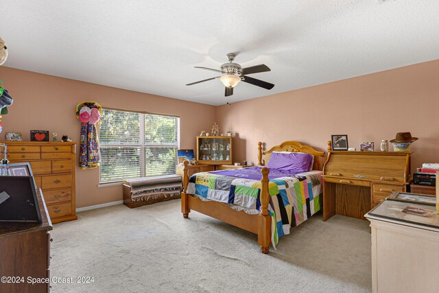 bedroom featuring ceiling fan, a textured ceiling, and light carpet