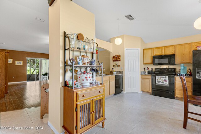 kitchen with black appliances, light brown cabinetry, and light hardwood / wood-style floors