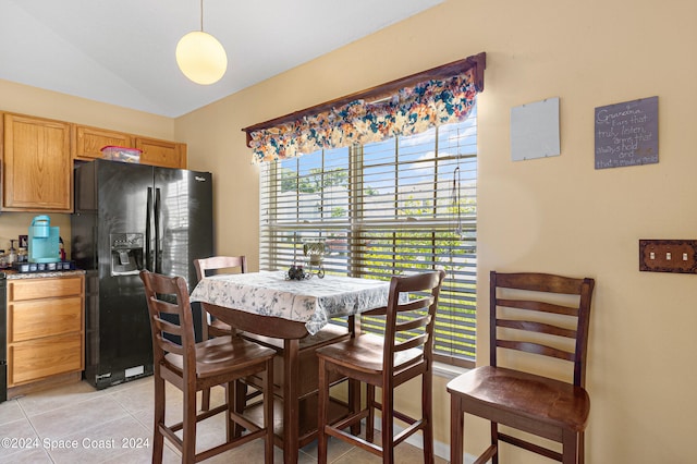 tiled dining room with vaulted ceiling