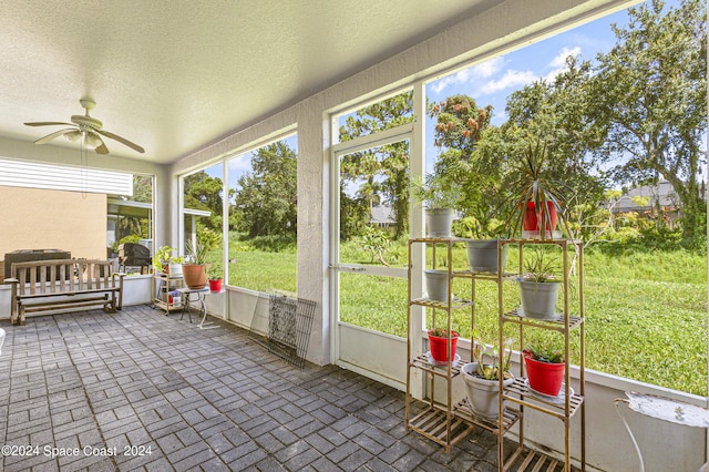 unfurnished sunroom featuring ceiling fan