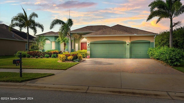 view of front of house featuring a garage and a yard