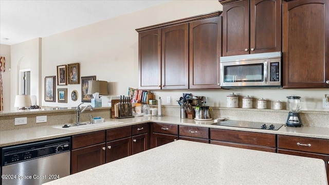 kitchen featuring dark brown cabinets, stainless steel appliances, sink, and kitchen peninsula