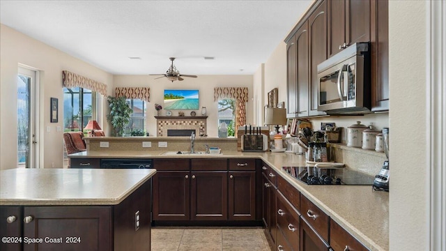 kitchen featuring ceiling fan, kitchen peninsula, black electric stovetop, light tile patterned floors, and sink