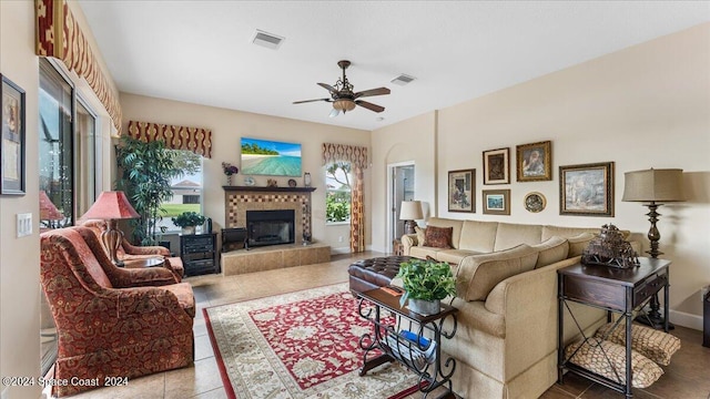 living room featuring a fireplace, tile patterned flooring, and ceiling fan