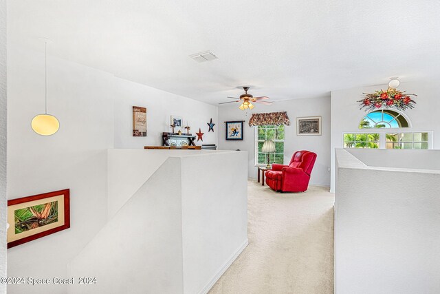 interior space featuring ceiling fan and carpet