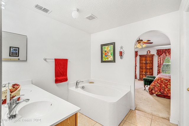 bathroom featuring a bathtub, vanity, tile patterned floors, ceiling fan, and a textured ceiling