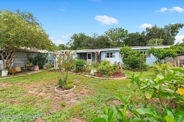 ranch-style house featuring a front yard and fence