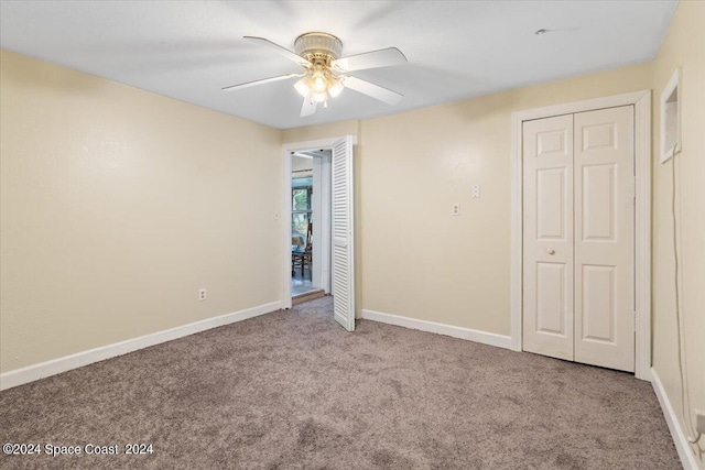 unfurnished bedroom featuring ceiling fan, a closet, and light colored carpet