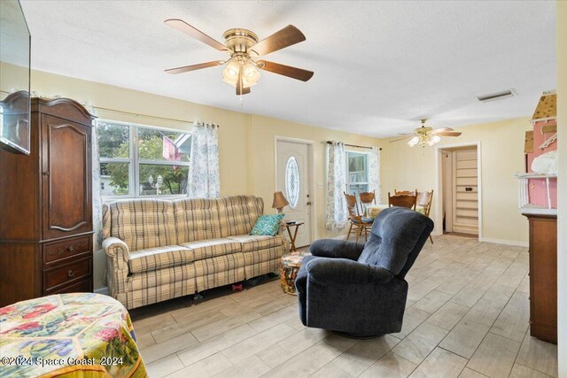 living room with light hardwood / wood-style flooring and ceiling fan