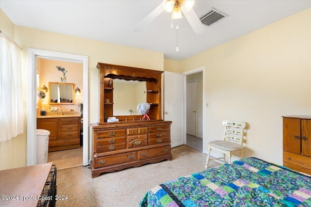 bedroom featuring visible vents, a ceiling fan, light carpet, connected bathroom, and a sink