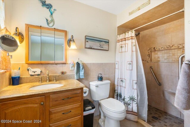 full bath with toilet, a wainscoted wall, vanity, tile walls, and a shower stall