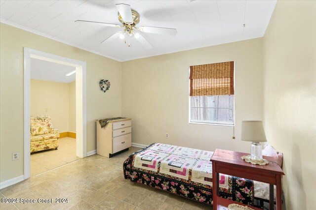 tiled bedroom featuring ceiling fan and ornamental molding