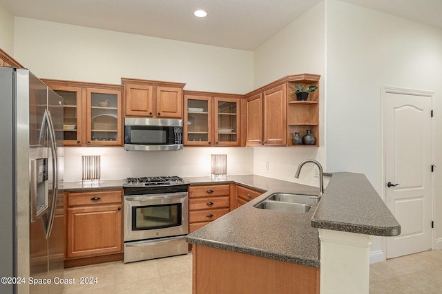 kitchen with light tile patterned flooring, appliances with stainless steel finishes, kitchen peninsula, and sink