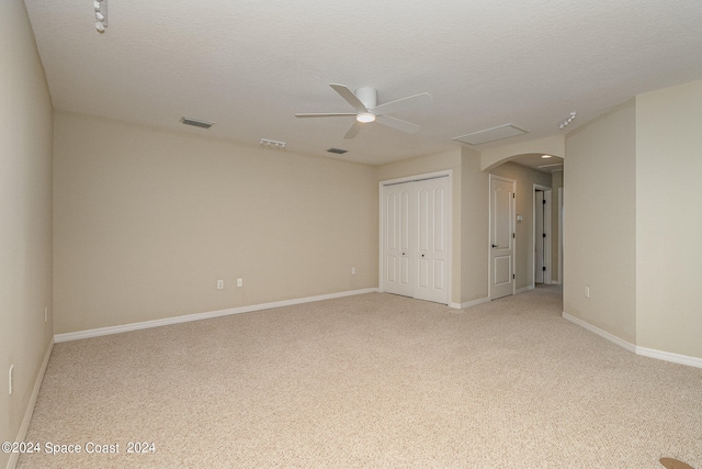 interior space featuring ceiling fan, a textured ceiling, and light carpet