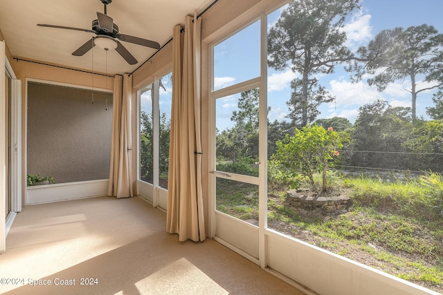 unfurnished sunroom featuring ceiling fan