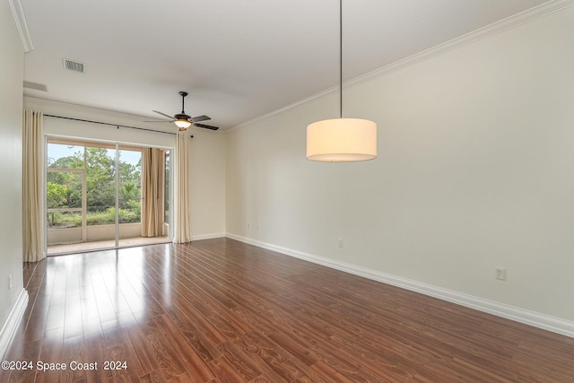 spare room featuring crown molding, dark wood-type flooring, and ceiling fan