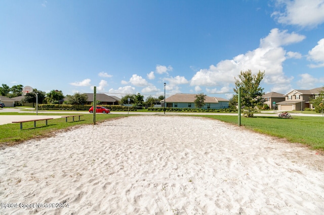 surrounding community featuring a garage, volleyball court, and a yard