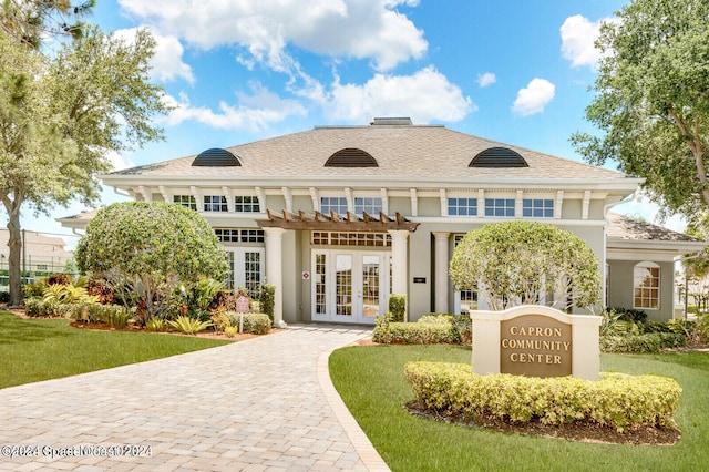 view of front of house with french doors and a front lawn