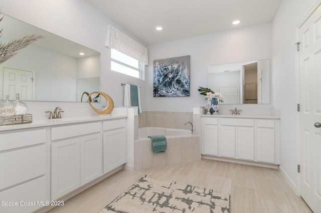 bathroom with vanity and tiled tub